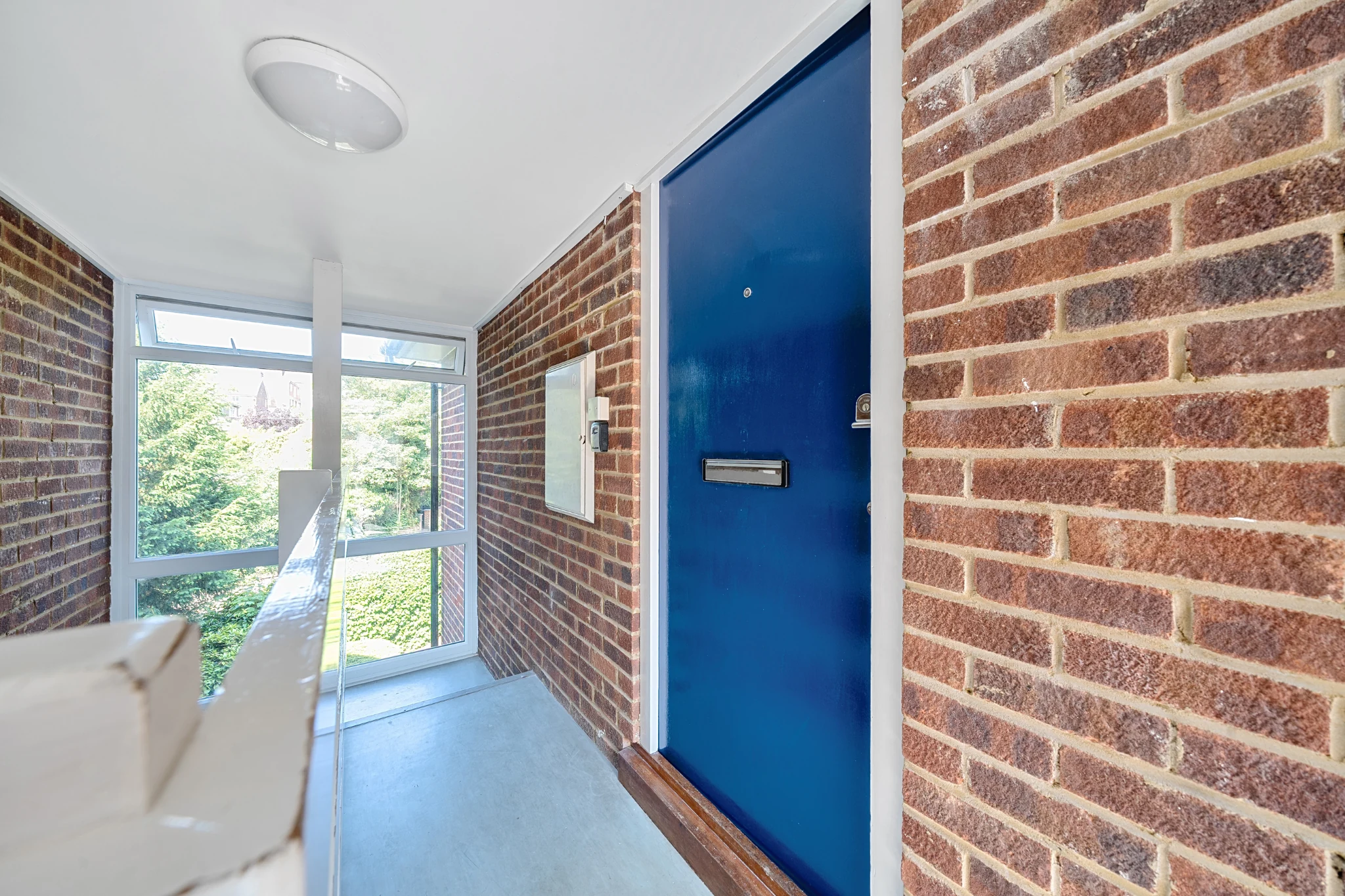 Blue entrance door and entrance hall at Ravenswood Court