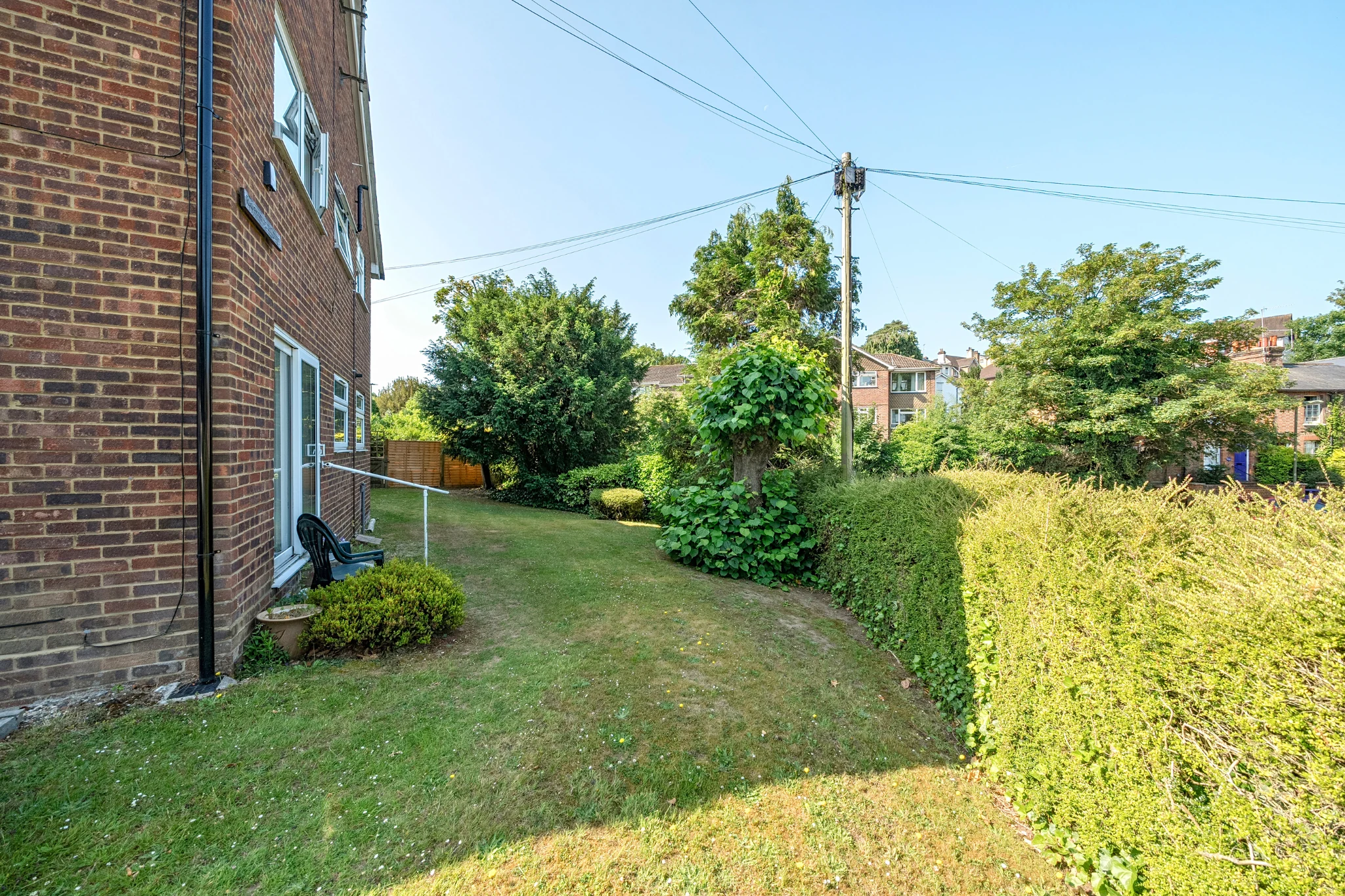 Shared garden path and lawn beside the brick buildings